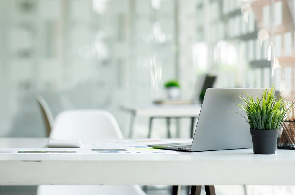 A tidy home-office desk with a laptop and reports — executive assistance